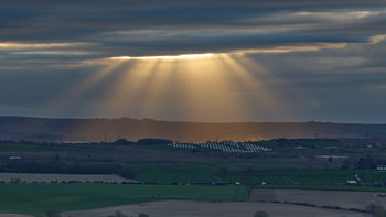 Gods rays on a cloudy spring evening over a solar farm 4.jpg